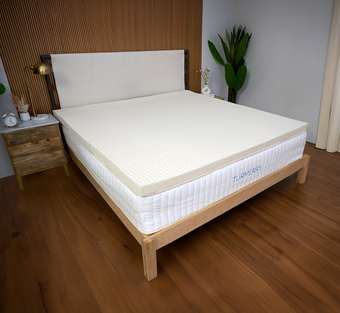 Turmerry Latex Mattress Topper on a Turmerry mattress on wooden bed frame in modern bedroom setting.