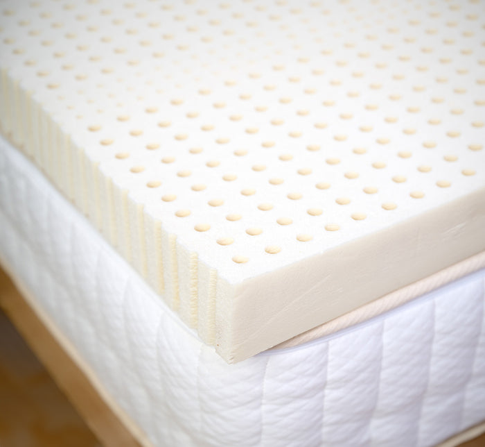 Close-up of Turmerry Organic Latex Mattress Topper edge showing perforated Dunlop latex layer.