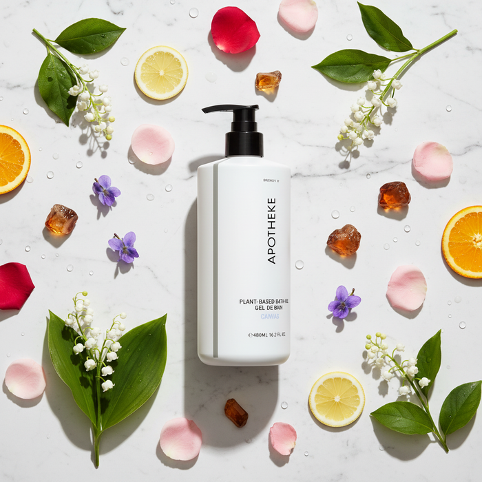 Apotheke Canvas hotel bath gel 480ml flat lay on white marble with lily of the valley rose violet citrus peach amber scent elements — luxury plant-based body wash