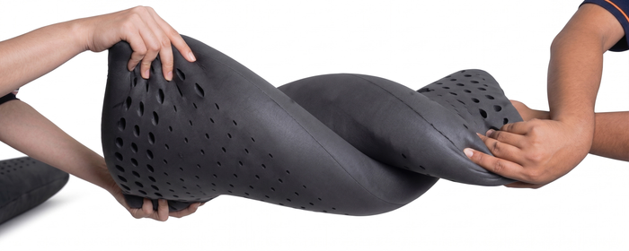 Two hands holding and twisting Turmerry Cooling Pillow horizontally, demonstrating flexibility.