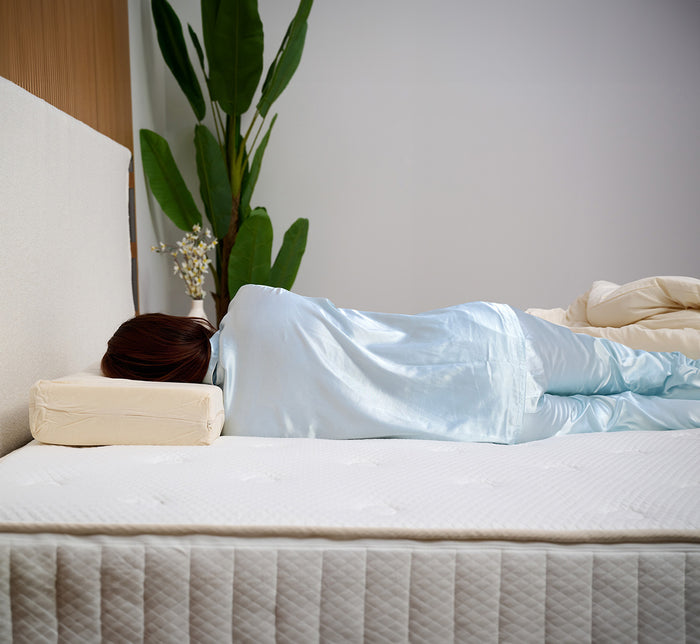 Backside of woman lying on her side on Turmerry Cuboid Pillow.