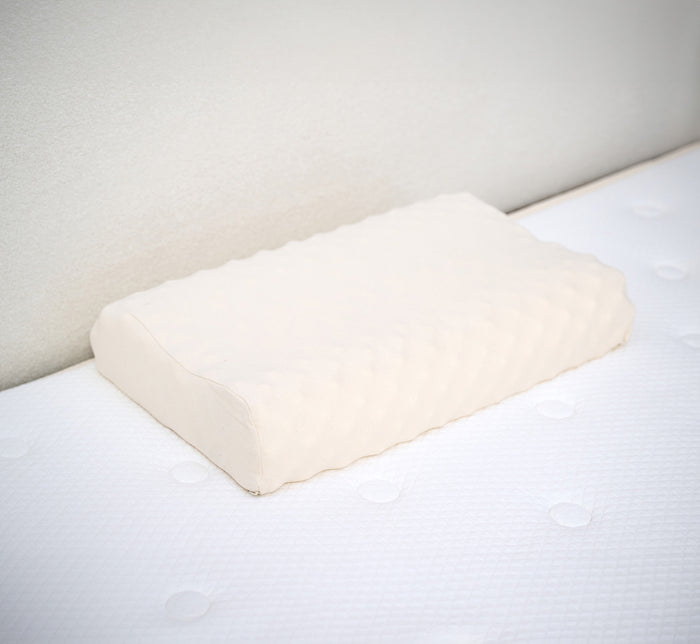 Turmerry eggcrate latex contour pillow with white cover displayed on white bed.