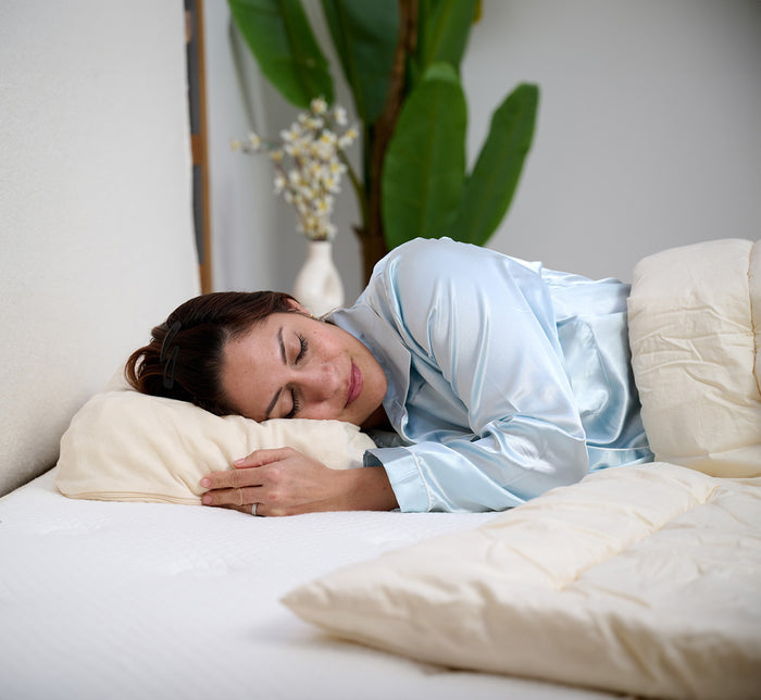 Woman sleeping on her side on Turmerry eggcrate latex contour pillow in modern bedroom.