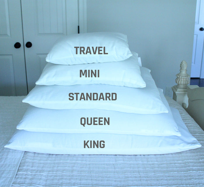 Five Turmerry Hybrid Pillows stacked on bed labeled Travel, Mini, Standard, Queen, and King by size.