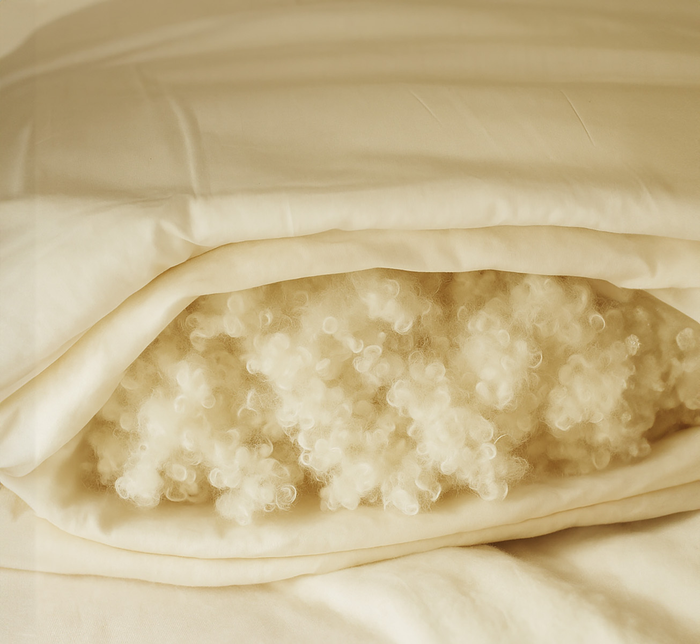 Close-up of wool fill inside white bedding.