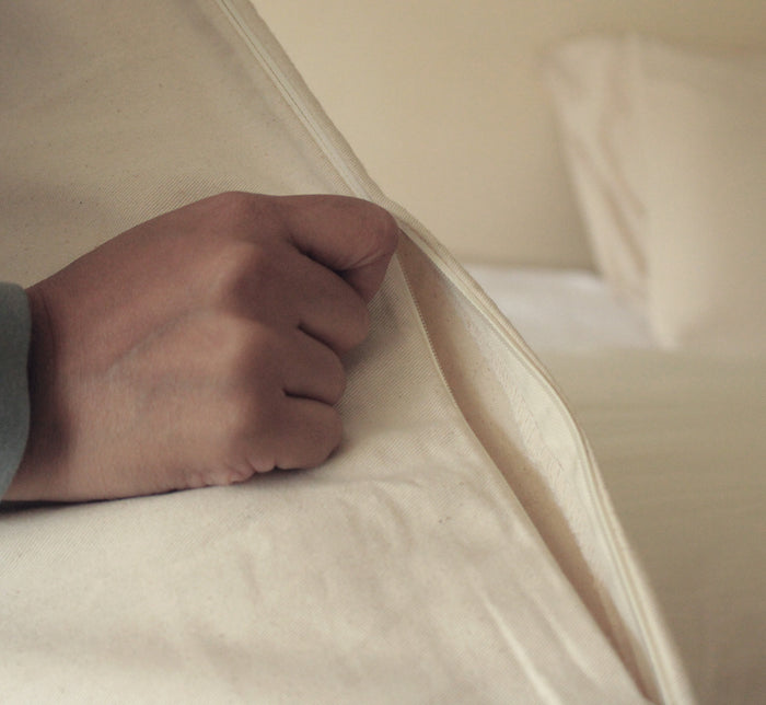 Hand zipping open Turmerry Hybrid Pillow cover.