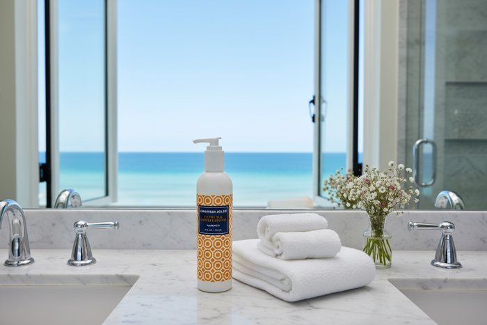 Jonathan Adler Citrus & Sandalwood Shampoo on marble vanity with ocean view