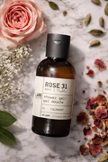Le Labo Rose 31 Travel Size Shower Gel 60ml with rose petals on a marble surface.