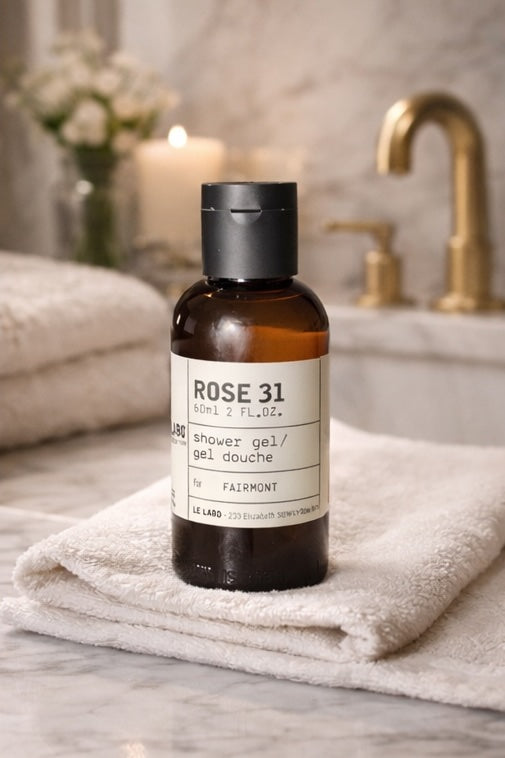 Le Labo Rose 31 travel size shower gel bottle on a towel in a luxurious bathroom setting.
