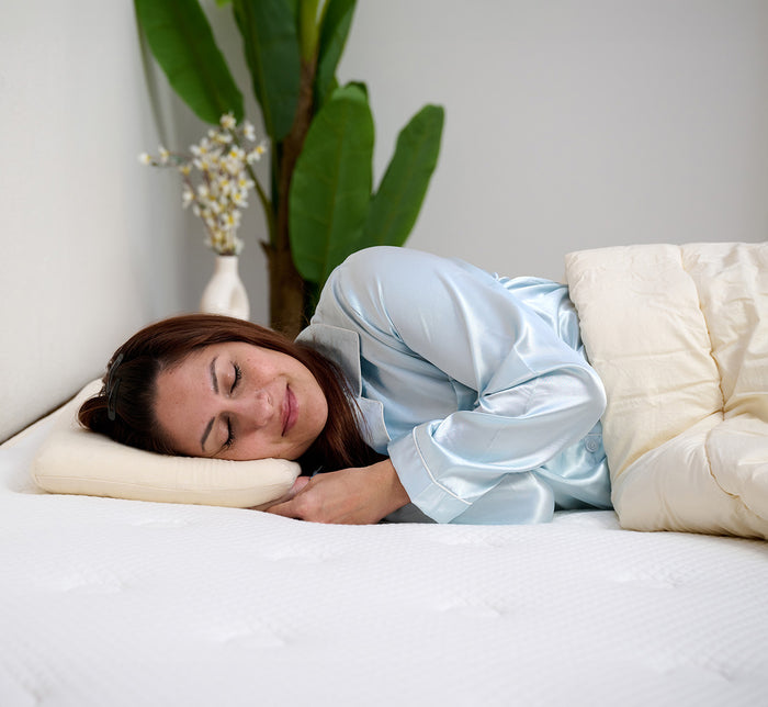 Woman sleeping peacefully on her side on Turmerry low profile toddler pillow.