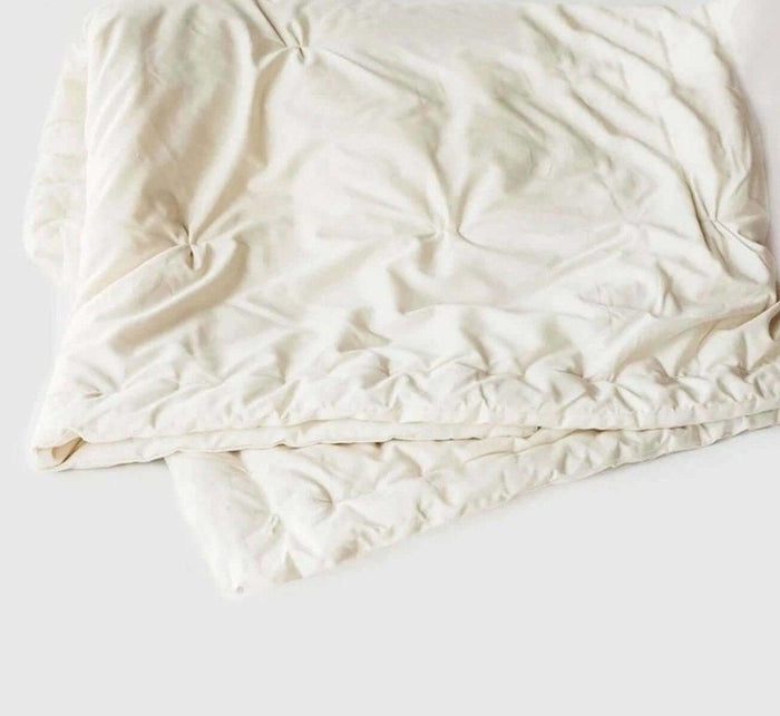 Turmerry made in USA lightweight natural wool comforter laid out, on white background.