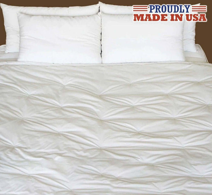 Turmerry made in USA lightweight natural wool comforter on bed with white pillows.