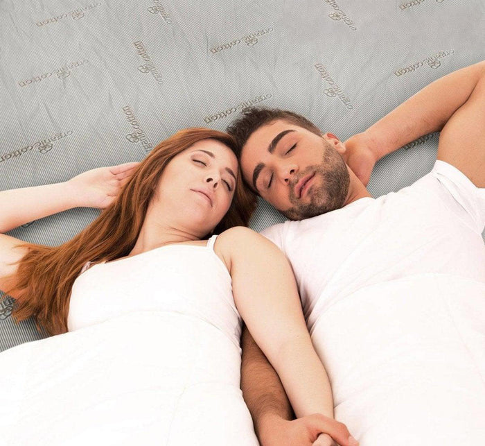 Couple sleeping peacefully on bed with Turmerry Mattress Topper Encasement visible underneath.