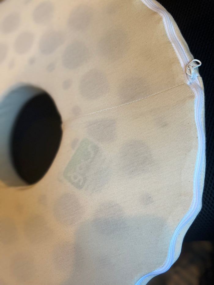 Close-up of Turmerry latex donut pillow showing white cover and perforation detail.