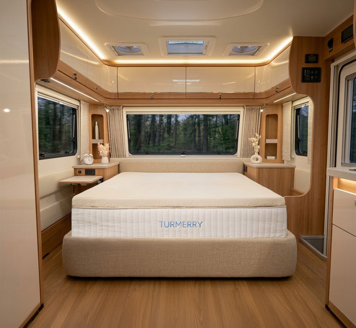 Turmerry Latex RV Mattress Topper centered on Turmerry bed in narrow RV bedroom with large windows and wood trim throughout.