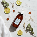 Sachajuan Hair Repair Conditioner flat lay with bergamot and botanicals on white marble