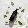 Sodashi Botanical Body Lotion flat lay with botanicals on white marble